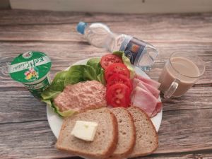 Zdjęcie przedstawia Dietę z ograniczeniem łatwoprzyswajalnych węglowodanów:  Masło extra  Kawa zbożowa z mlekiem Chleb Graham Szynka krucha z pieca wieprzowa, parzona Pasta twarogowa pomidorowo-selerowa Kefir 1,5% Woda mineralna  Sałata zielona Pomidor